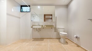 A modern bathroom with a toilet, sink, and shower. - Calucé Tesoro by letoH (Medellín)