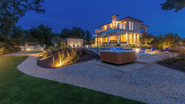 A modern house with a swimming pool, outdoor seating, and a well-lit patio area. - Villa Roko (Malinska-Dubasnica)
