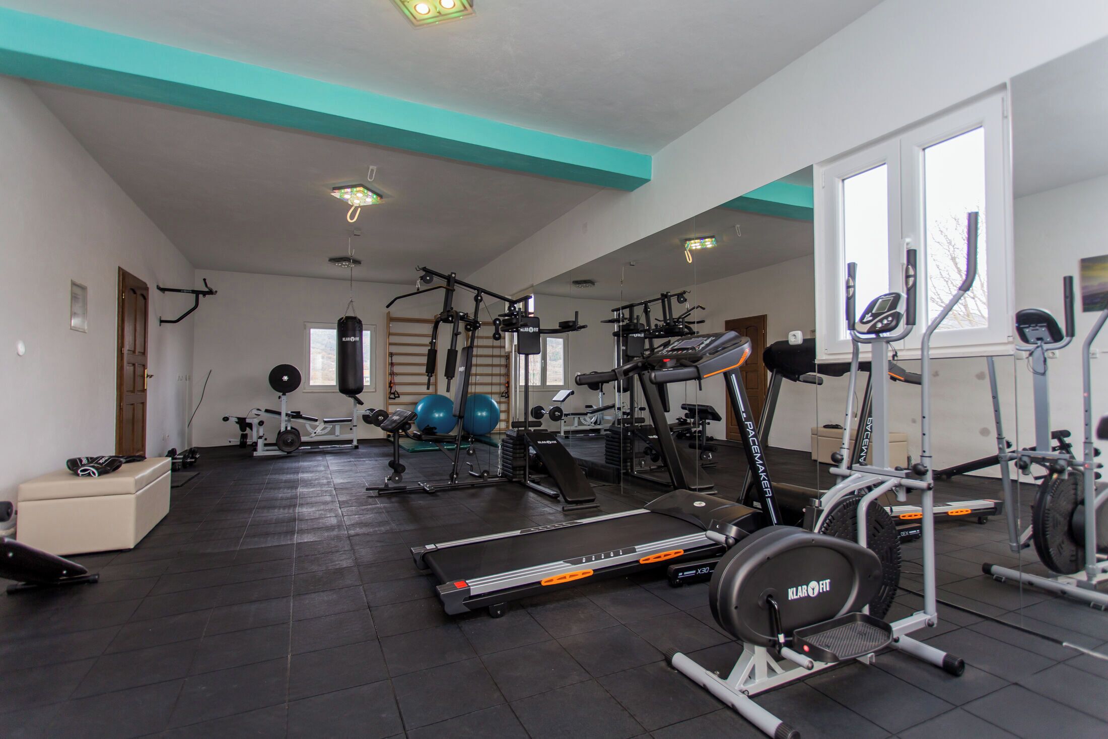 A spacious gym with various exercise equipment, including treadmills, weight machines, and free weights.