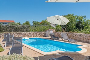 Una piscina al aire libre, sombrillas