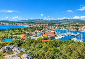A coastal town with a marina, buildings with red roofs, and a clear blue sky. - Villa Grgo (Rogoznica)
