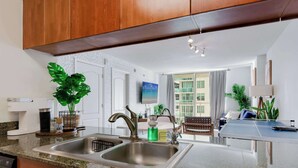 Una cocina moderna con encimeras de granito, pileta de acero inoxidable y muebles de madera.