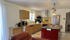 Una cocina moderna con armarios de madera, una isla central y una pared de acento roja.