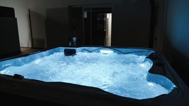 A hot tub with a glass enclosure, a bottle, and a chair in the background. - IDEAL HOUSE TO DISCONNECT FROM THE ROUTINE.  SUN, SEA AND RELAXATION. (Las Playitas)