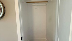 Un couloir étroit doté d’un plancher en bois et d’un chambranle de porte blanc.