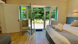 Una camera da letto con un letto, una sedia e una porta che dà su un balcone.
