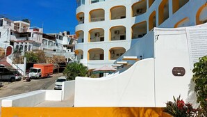 A multi-story hotel with a curved facade, balconies, and a clear blue sky. - Loft with ocean view! "Twin Towers Tres Mares" (Acapulco de Juárez)