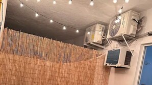 A room with a bamboo wall, two wicker sofas, string lights, and air conditioning units. - Loft with ocean view! "Twin Towers Tres Mares" (Acapulco de Juárez)