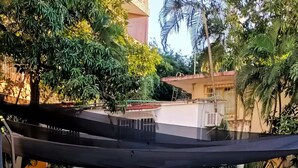 A swimming pool with a logo, surrounded by a covered area with plants and a building in the background. - Loft with ocean view! "Twin Towers Tres Mares" (Acapulco de Juárez)