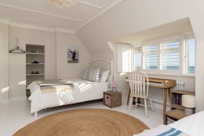 A bedroom with a bed, a desk, a chair, a radiator, and a window with a view. - Luxury Beachfront Retreat for 14 With Hot Tub (Bognor Regis)