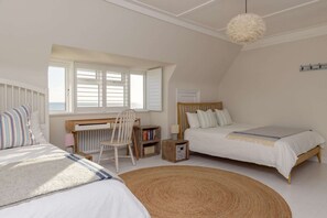 A bedroom with two beds, a desk, a chair, a bookshelf, and a large window. - Luxury Beachfront Retreat for 14 With Hot Tub (Bognor Regis)