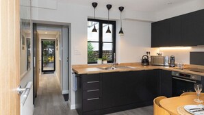 Une cuisine moderne avec des meubles noirs, un plan de travail en bois et une fenêtre offrant une belle vue.
