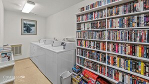 A library with white shelves filled with books and magazines, a sink, and a framed picture on the wall. - Young at Heart Chalet, Pet Friendly- 507 (Crescent Lake Junction)
