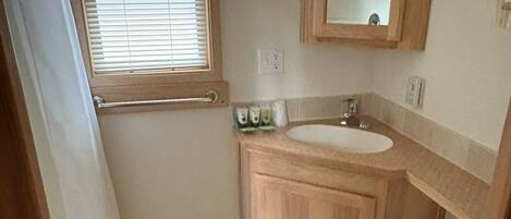 A small bathroom with a wooden vanity, a sink, and a toilet.