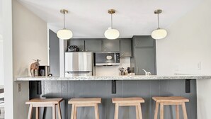 A kitchen with a central island, bar stools, and pendant lighting. - Discovery 4 111:Near Canyon Lodge, Dog Friendly (Mammoth Lakes)
