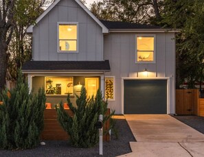 A two-story house with a garage, a front porch with steps, and a driveway. - Urban retreat w/Spa, Movie, Mini-Golf in DT/6th St (Austin)