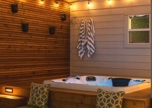 A hot tub with a wooden wall and hanging towels. - Urban retreat w/Spa, Movie, Mini-Golf in DT/6th St (Austin)
