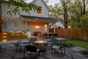 Un jardin avec un foyer, des sièges d’extérieur et une terrasse en bois.