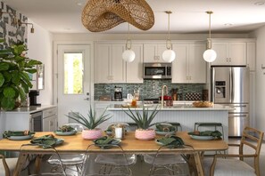 A modern kitchen with white cabinets, stainless steel appliances, and a central island. - Urban retreat w/Spa, Movie, Mini-Golf in DT/6th St (Austin)