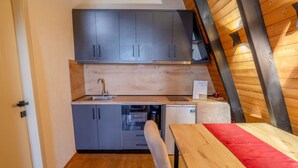 A compact kitchen with grey cabinets, a wooden countertop, and a built-in oven. - Grey Retreat The Golden Cabins With Garden (Gjinar)