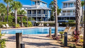 A pool area with lounge chairs and a two-story building with balconies. - Seacrest, Steps to Beach & Pools! 4 Bikes Included, Pet Friendly! (Rosemary Beach)