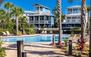 A pool area with lounge chairs and a two-story building with balconies. - Seacrest, Steps to Beach & Pools! 4 Bikes Included, Pet Friendly! (Rosemary Beach)