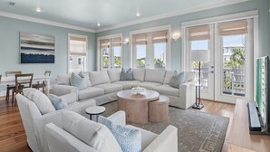 A spacious living room with a sectional sofa, a round coffee table, and a dining area with a table and chairs. - EZ Walk 2 Beach! Private Pool, LSV, FirePit, & Bikes! Pet Friendly! (Santa Rosa Beach)