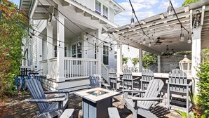 A covered outdoor seating area with Adirondack chairs and a fire pit. - Outdoor Oasis! Walk 2 Shops & Eat! LSV/Golf Cart, 3 Kings & Bikes! (Santa Rosa Beach)
