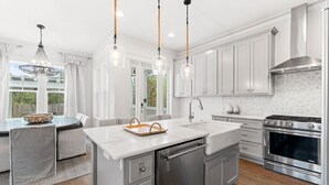 A modern kitchen with white cabinets, stainless steel appliances, and pendant lighting. - Outdoor Oasis! Walk 2 Shops & Eat! LSV/Golf Cart, 3 Kings & Bikes! (Santa Rosa Beach)