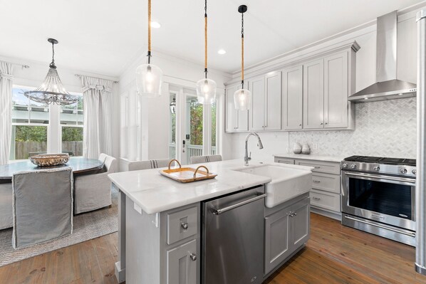 A modern kitchen with white cabinets, stainless steel appliances, and pendant lighting. - Outdoor Oasis! Walk 2 Shops & Eat! LSV/Golf Cart, 3 Kings & Bikes! (Santa Rosa Beach)