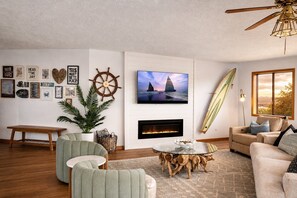 Sala de estar com lareira, televisão e decoração náutica.