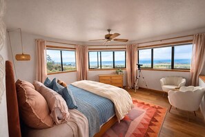 Un dormitorio con cama, cómoda, silla y un telescopio.
