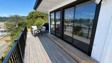 A balcony with a view of a parking area and trees.