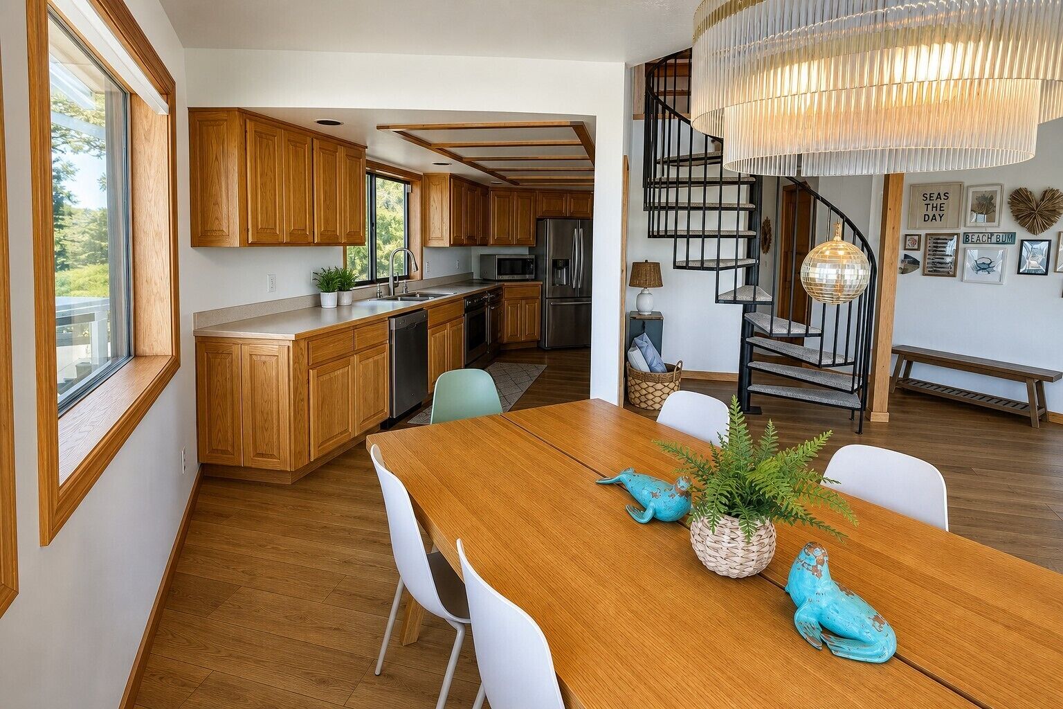 Eine moderne Küche mit Holzausstattung, ein Essbereich mit Holztisch und eine Treppe mit schwarzer Geländer.
