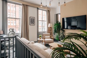 A modern living room with a sofa, armchairs, a TV, and a dining table. - Chic 2-bed City Apartment -old Street (London)