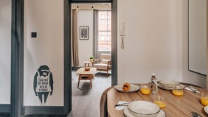 Un coin repas avec une table mise pour le petit-déjeuner, comprenant des assiettes, des verres et un croissant.