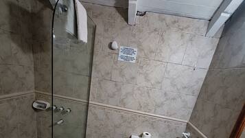 Un baño con ducha acristalada, un bidé, un inodoro y una encimera de granito con lavabo.