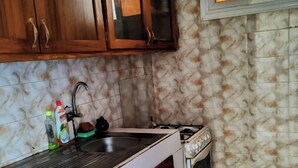 Une cuisine avec des meubles de rangement en bois, un évier, une cuisinière et une fenêtre donnant sur un beau paysage.