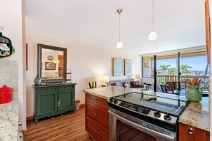 A kitchen with a stove, cabinets, and a view of the outdoors. - Maui Vista 2310 - Fully Remodeled 1 BR/1 BA Close to Beach (Kihei)