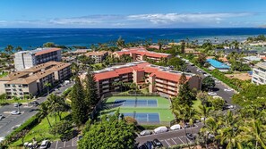 A coastal hotel complex with multiple buildings, a tennis court, and a view of the ocean. - Maui Vista 2310 - Fully Remodeled 1 BR/1 BA Close to Beach (Kihei)