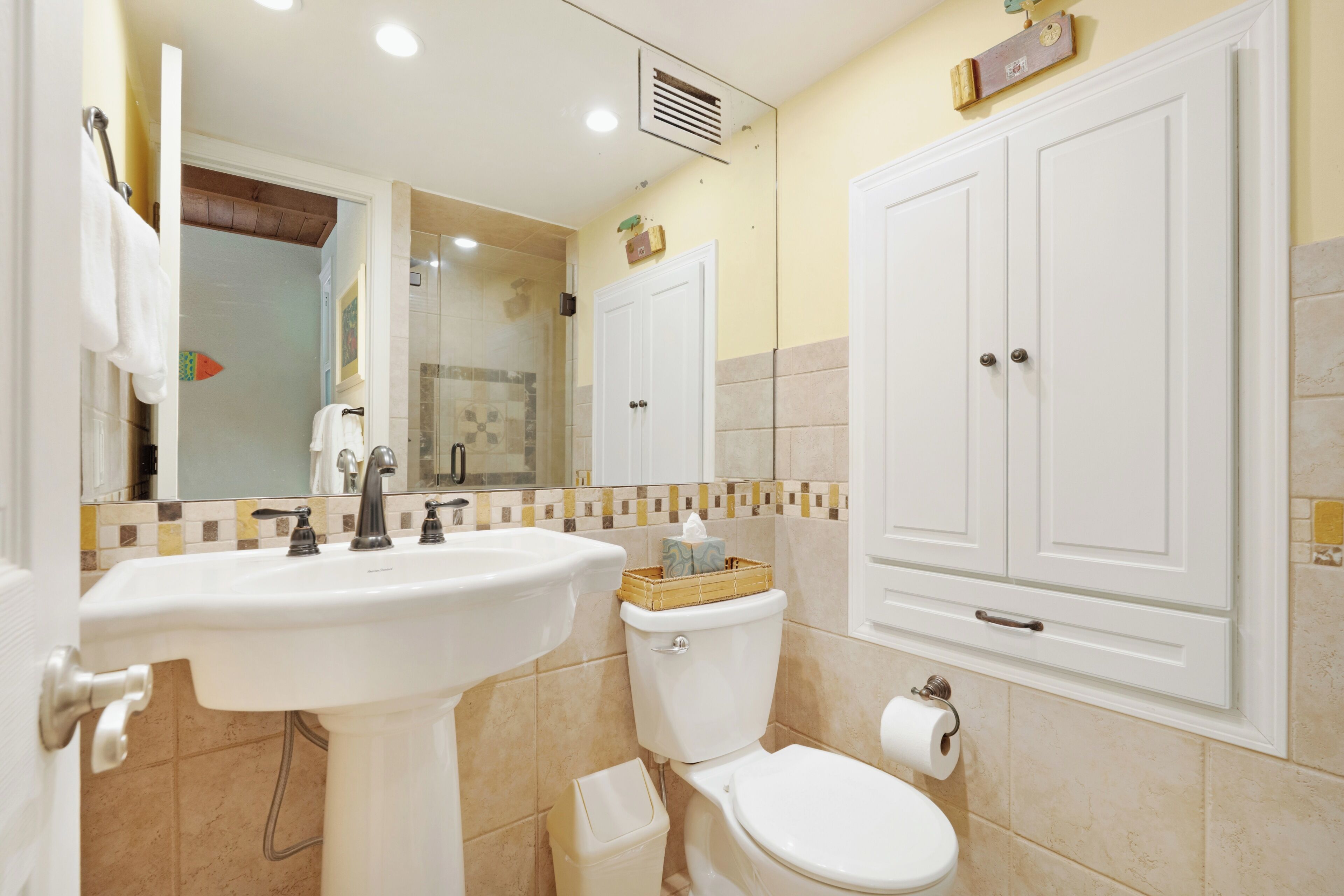 Baño con lavabo, inodoro y espejo.