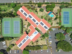 An aerial view of a sports complex with tennis courts, a swimming pool, and solar panels on the roof. - Maui Vista 3312 - Updated & Comfortable 1 BR/1 BA near Beach (Kihei)