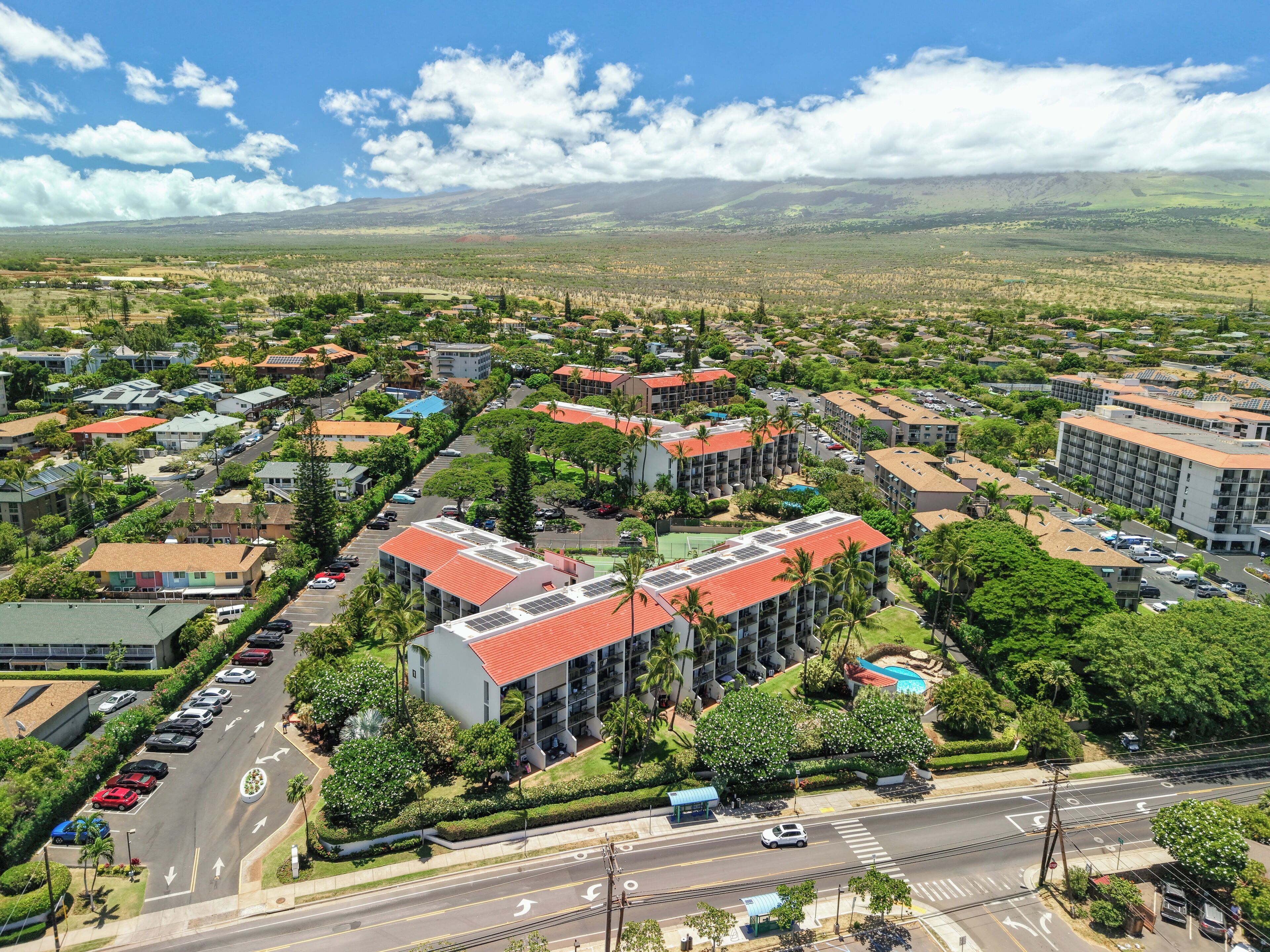 A residential area with multiple buildings, roads, and greenery.