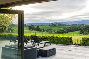 A patio with outdoor furniture overlooking a green landscape. - Hahndorf Farm Barn (Hahndorf)