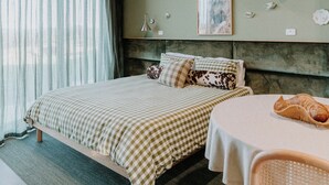 A bedroom with a bed, a table, and a chair. - Hahndorf Farm Barn (Hahndorf)