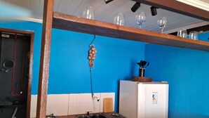 Une cuisine avec un mur bleu, un réfrigérateur blanc, un évier et un plan de travail en bois.