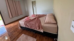 A bedroom with a bed, curtains, a window, and a door. - PORTAL DA LAGOA AZUL INN IN NOBRES (Coqueiral)
