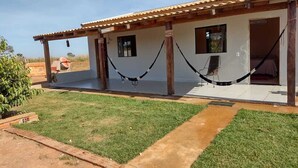 A two-story building with a tiled roof, a covered patio area, and a small garden. - PORTAL DA LAGOA AZUL INN IN NOBRES (Coqueiral)