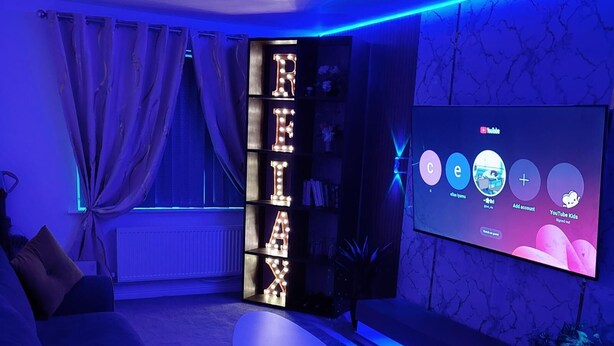 Un salon moderne avec un canapé, une table basse et un téléviseur fixé au mur.