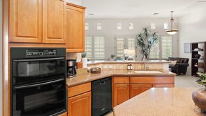 A modern kitchen with wooden cabinets, a built-in oven, and a dishwasher. - 4BR The Talon Trail Home: Pool, Spa,  Golf Access (Scottsdale)